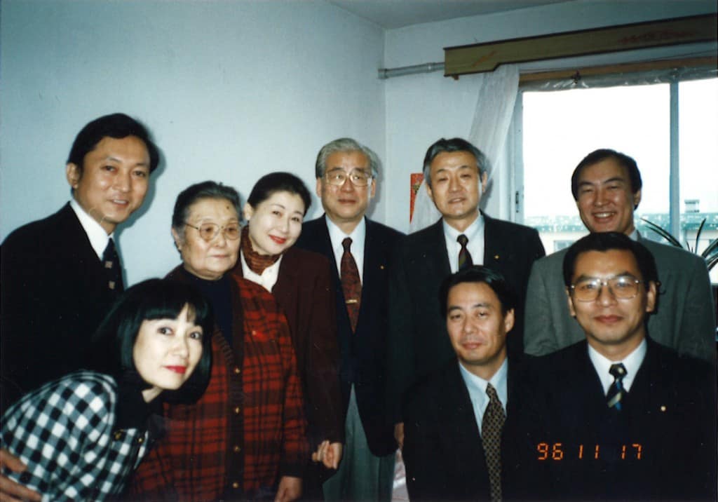 1996年 中国残留孤児養父母（左から３人目）を慰問に訪れる民主党結党後初の海外訪問団（前列左から）鳩山夫人、海江田万里、大畠章宏（後列左から）鳩山由紀夫、岡崎トミ子、山花貞夫、藤田、生方行夫（中国・大蓮）